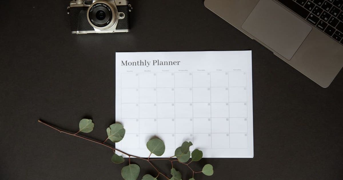검은 배경 위에 Monthly Planner 양식지, 필름 카메라, 노트북, 유칼립투스 가지